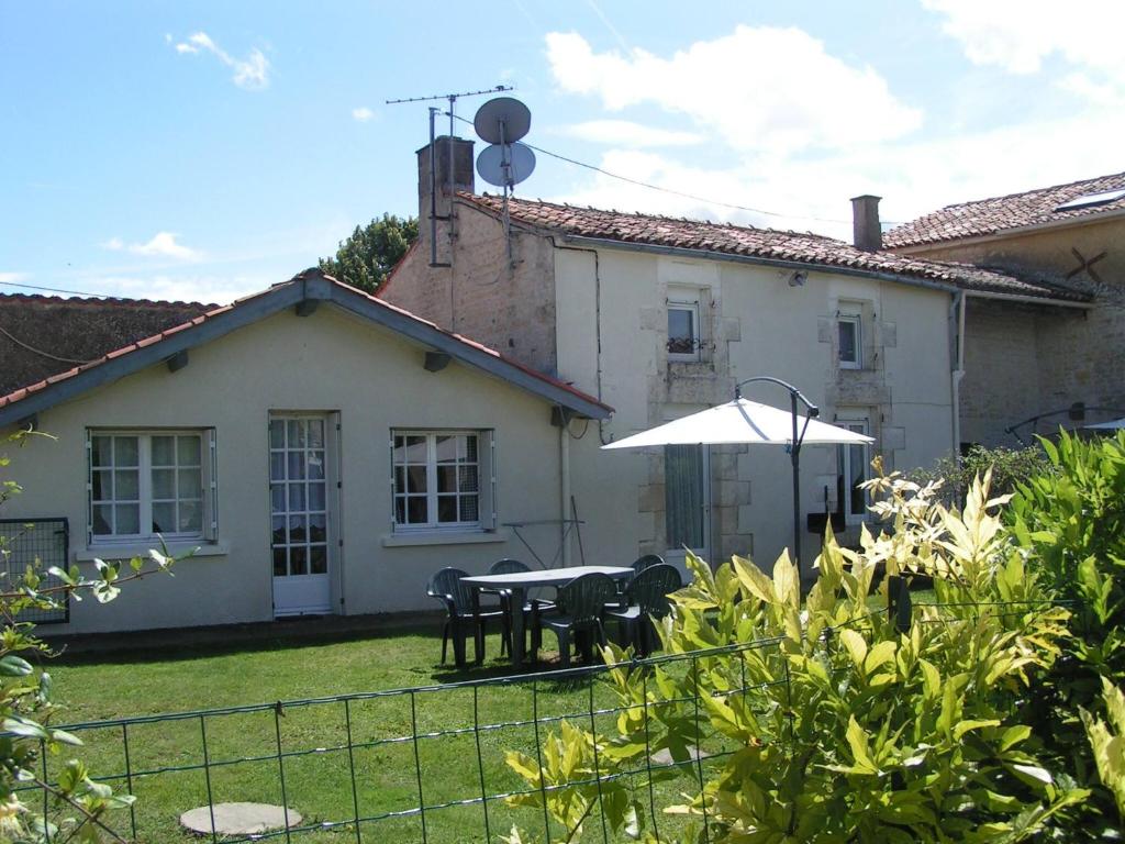 ein Haus mit einem Tisch und Stühlen im Hof in der Unterkunft Pegasus, Les Constellations in Doeuil-sur-le-Mignon