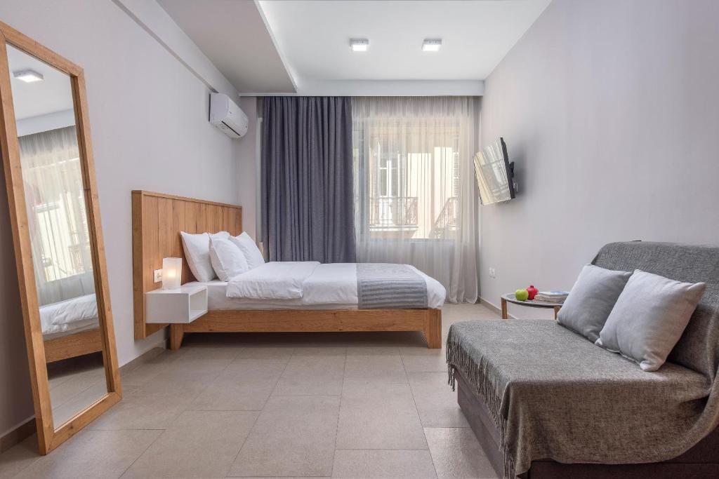 a bedroom with a bed and a couch and a mirror at Your City Level in Thessaloniki