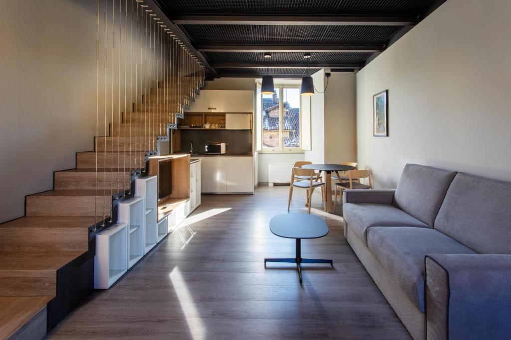 a living room with a couch and a table at Palazzo Le Poste - Suite and Apartments in Parma