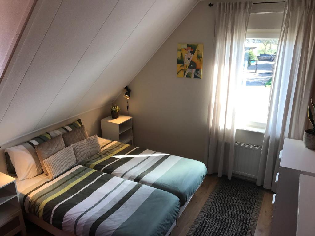 a bedroom with a bed and a window at Apartment Zonnehoek in Aagtekerke