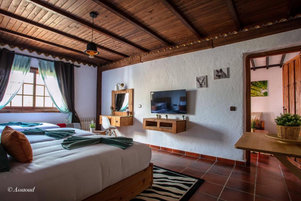 a bedroom with a large bed and a tv in it at Room in Bungalow - Triple Bungalow 6 - El Cortijo Chefchaeun Hotel Spa in Chefchaouen