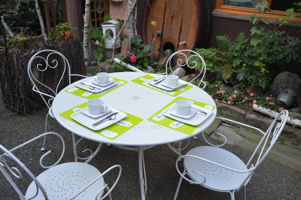 Chambres d'hôtes Chez Caroline في كولمار: طاولة بيضاء عليها كراسي وقبعات