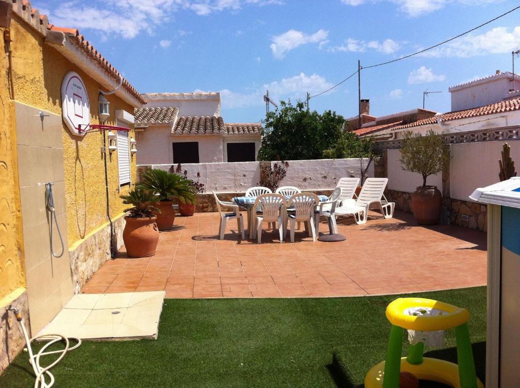 un patio con mesa y sillas en un patio trasero en Villa with garden and pool in Denia, en Denia