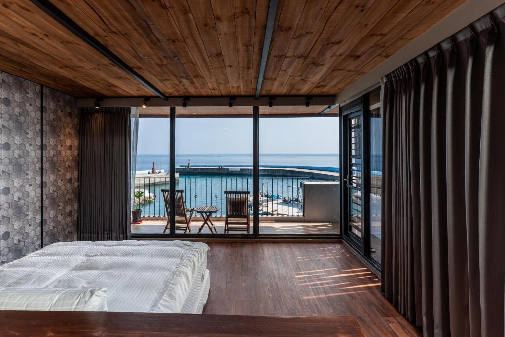 a bedroom with a bed and a view of the ocean at Marbordo B&B in Xiaoliuqiu