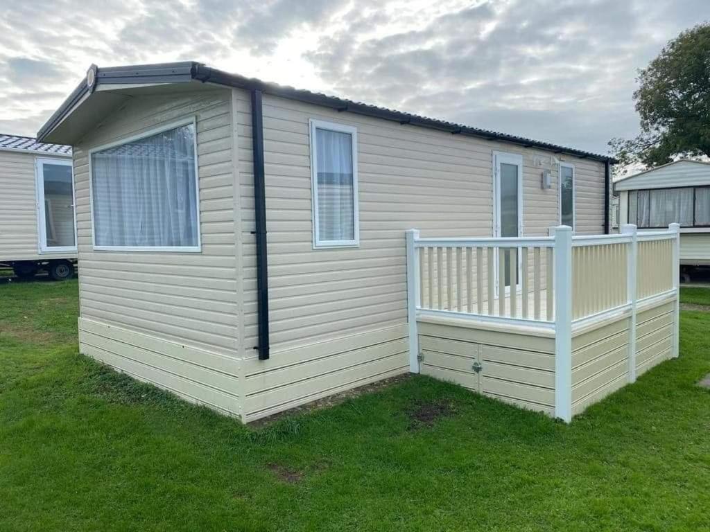 una pequeña casa con un porche en el césped en cabin zest, en Sandown
