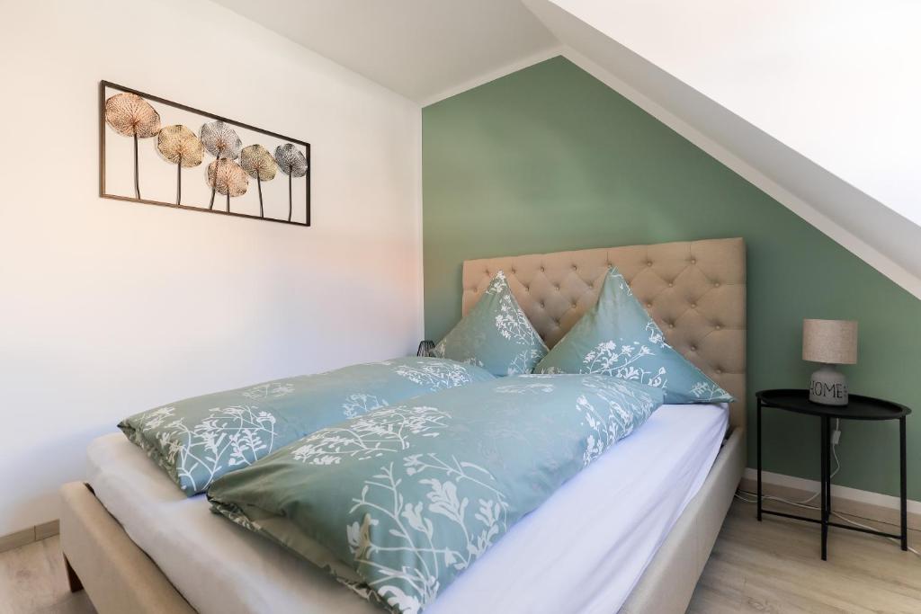 ein Schlafzimmer mit einem Bett mit blauen Kissen in der Unterkunft Ferienwohnung hinter der Krämerbrücke in Erfurt