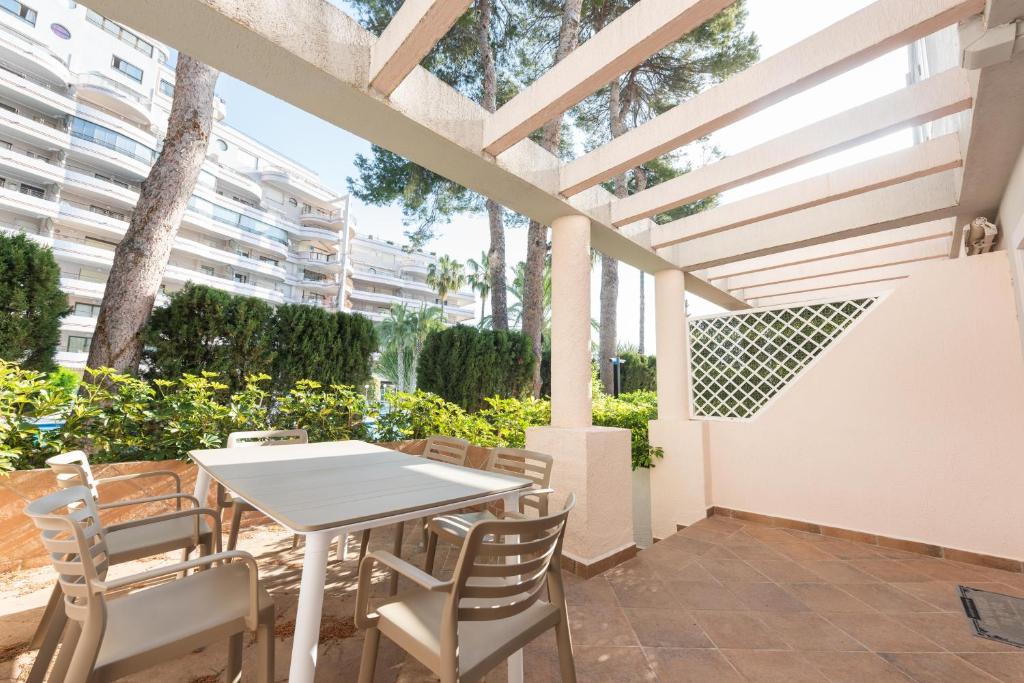 a patio with a white table and chairs at Martín- Bungalow a pie de playa V7 in Calpe