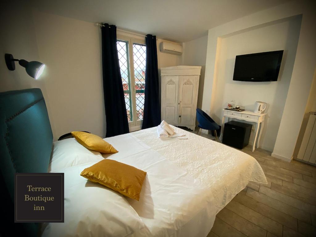 um quarto com uma grande cama branca com almofadas amarelas em Terrace Boutique Inn em Roma