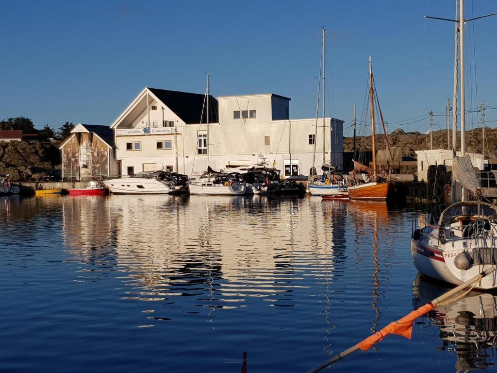 a group of boats are docked in a harbor at Utsira Overnatting - Sildaloftet in Utsira