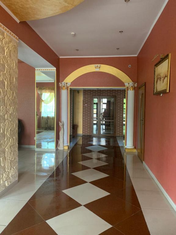 un corridoio con pareti arancioni e pavimento a scacchi di Avtoport Restorant Hotel Complex a Vinnycja