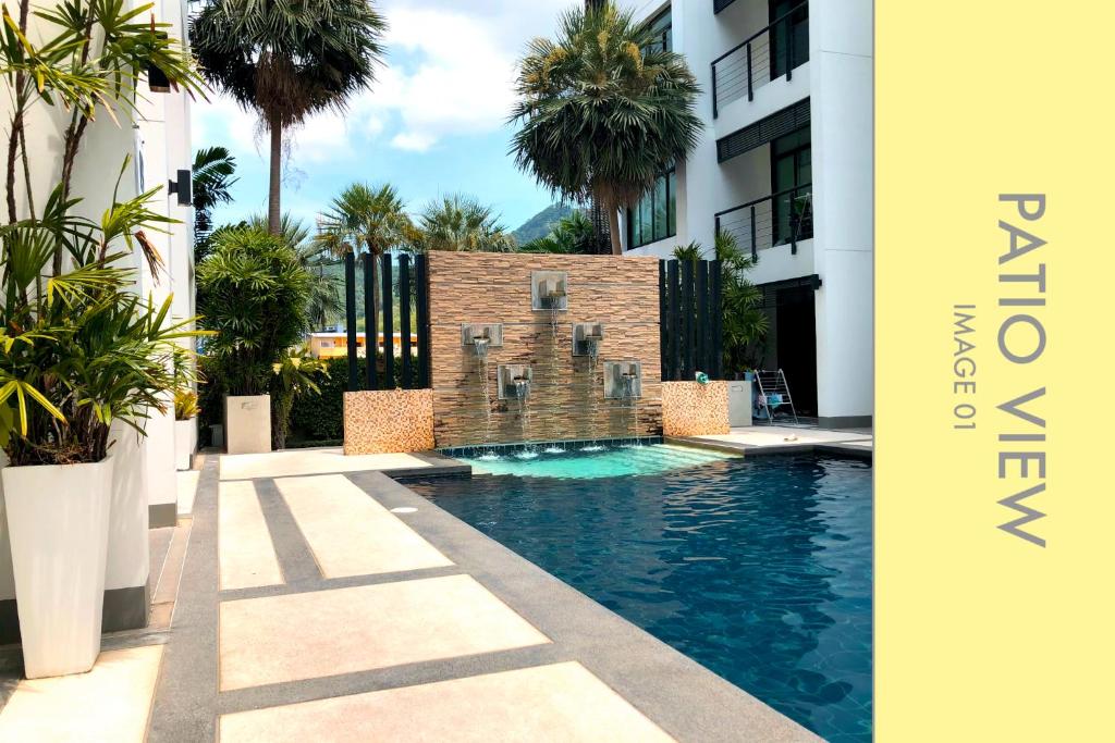 卡馬拉海灘的住宿－Pool Access 2 BDR Stylish Condo，棕榈树建筑中间的游泳池