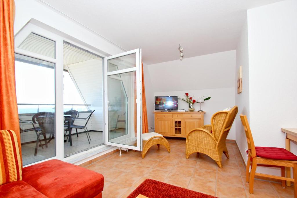 TV a/nebo společenská místnost v ubytování hafennahe Ferienwohnung mit Balkon und Meerblick - Hafenhäuser Wiek Wohnung 06