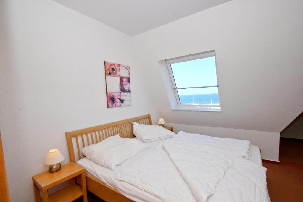 Postel nebo postele na pokoji v ubytování hafennahe Ferienwohnung mit Balkon und Meerblick - Hafenhäuser Wiek Wohnung 06