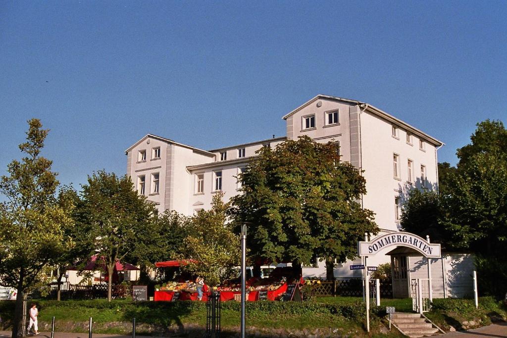 ein großes weißes Gebäude mit einem Baum davor in der Unterkunft Ferienwohnung mit eigener Sauna in zentraler Lage - Kurhaus Nordstrand FeWo 32 in Göhren