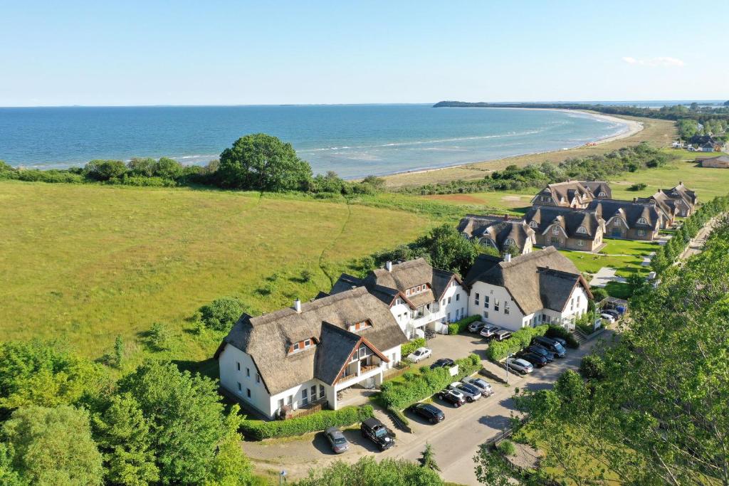 una vista aérea de una casa con coches aparcados en strandnah mit Terrasse, gratis Nutzung vom AHOI Erlebnisbad und Sauna in Sellin - Strandhaus Mönchgut FeWo06, en Lobbe