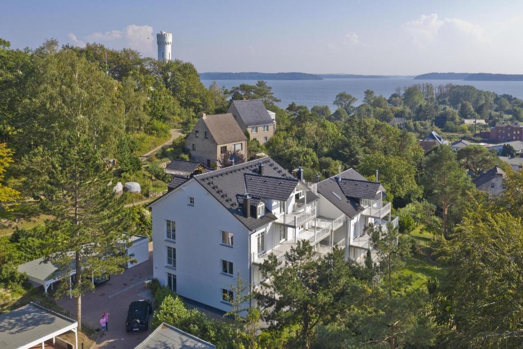 an aerial view of a house on a hill next to the water at moderne Ferienwohnung mit Kamin, Balkon - Ferienresidenz Zwei Bodden FeWo111 in Lietzow