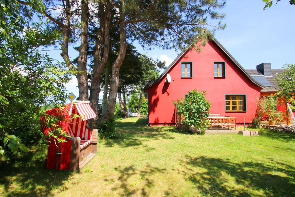a red house with a bench in the yard at strandnahe, schicke FeWo mit Terrasse und Garten - Ferienwohnung Silas in Thiessow