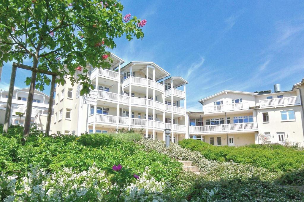 ein großes weißes Gebäude mit Blumen davor in der Unterkunft mit Meerblick und Balkon, gratis Nutzung vom AHOI Erlebnisbad und Sauna in Sellin - Meeresblick FeWo 38 in Göhren