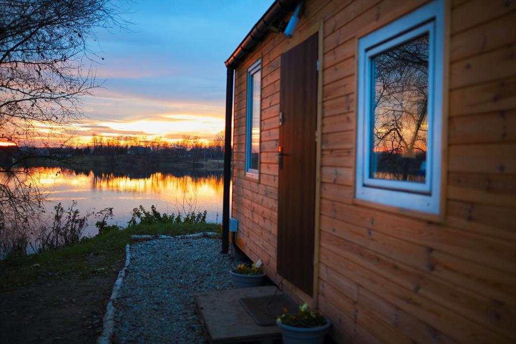 a building with a window next to a body of water at Domki Przystań in Kryspinów