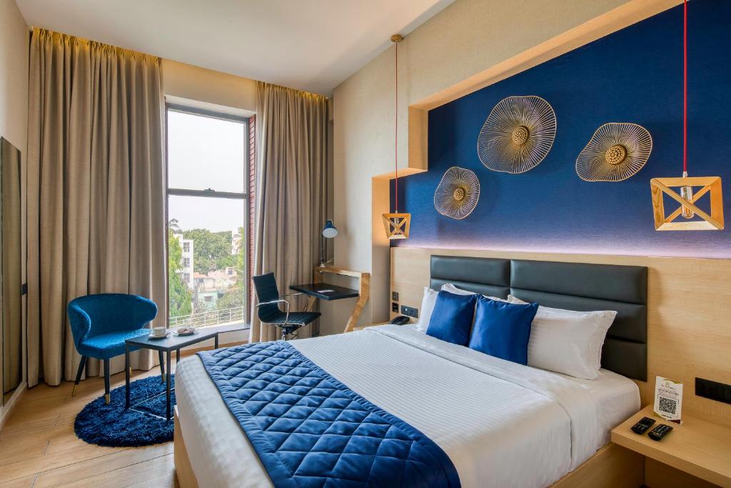 a hotel room with a bed and a blue wall at Le Foliage by TGI in Bangalore