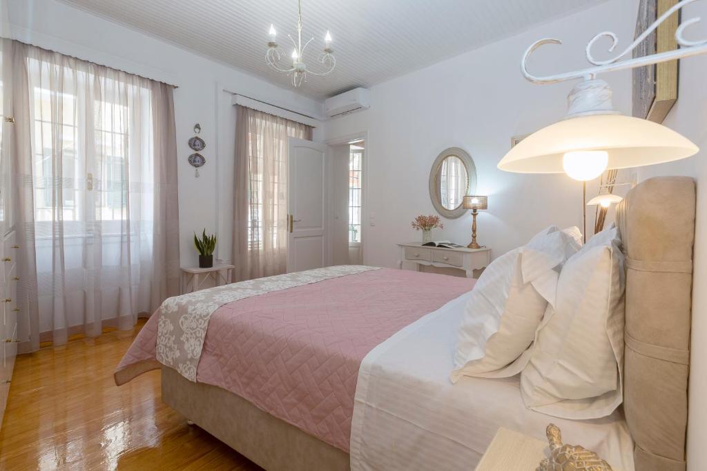 sypialnia z dużym łóżkiem i żyrandolem w obiekcie Nobilis Corfu apartment w Korfu