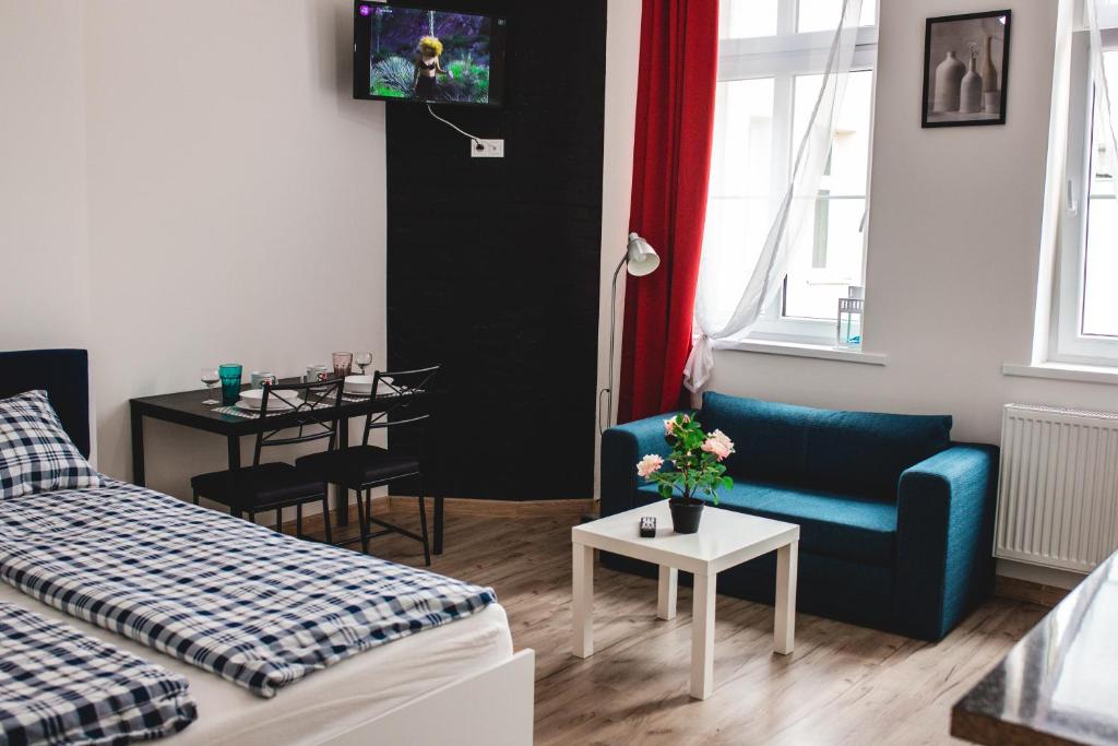 a living room with a bed and a couch and a table at SouvenirAppart Wilenska in Bydgoszcz