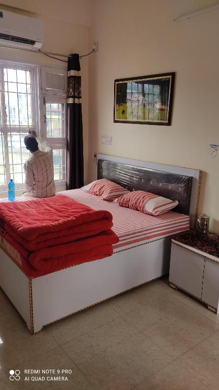 ein Schlafzimmer mit einem großen Bett mit roter Bettwäsche in der Unterkunft CITY CROWN GUEST HOUSE in Sundarnagar