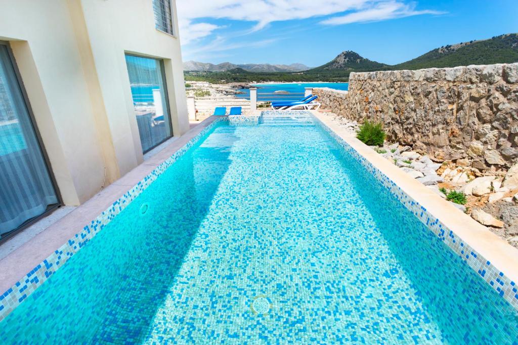 een zwembad in een villa met uitzicht op de oceaan bij Cala Agulla 1 in Cala Ratjada