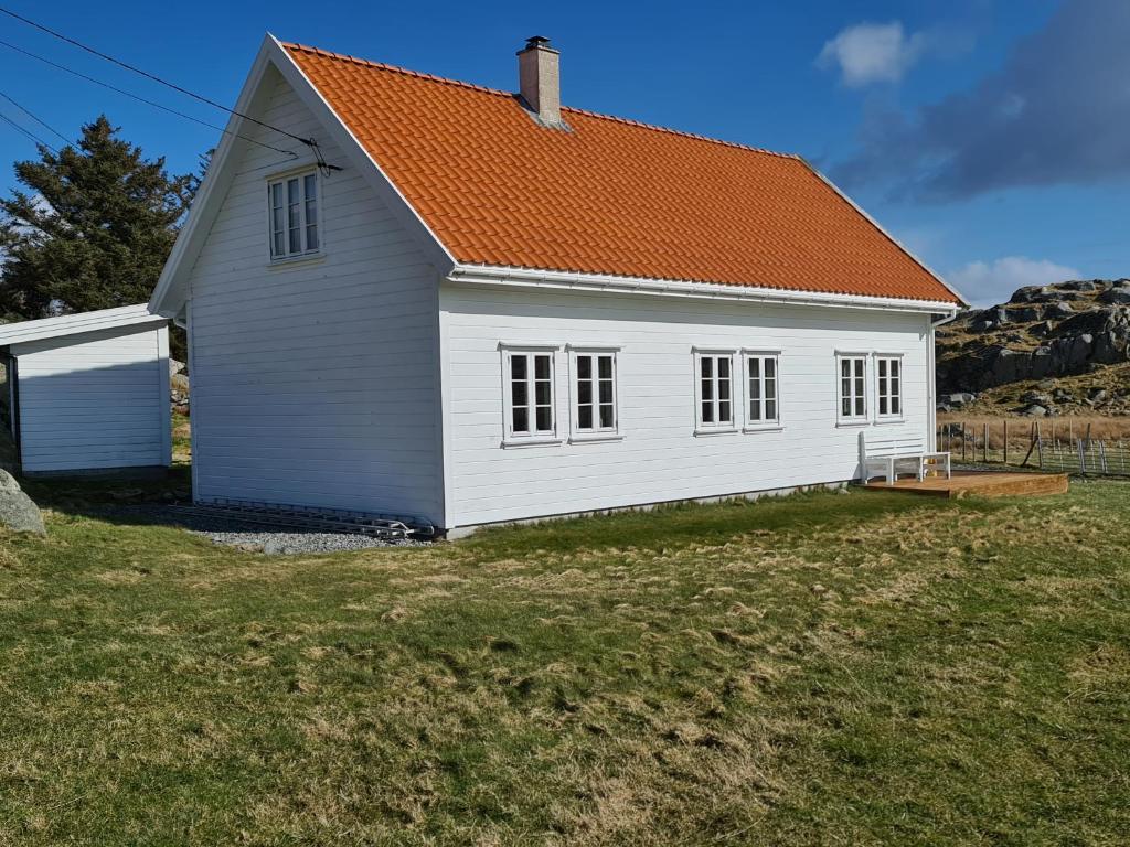 uma casa branca com um telhado laranja em Utsira Overnatting - Kvalvik em Utsira