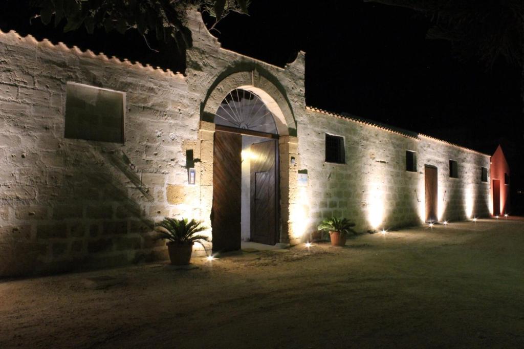 un bâtiment avec une porte éclairée la nuit dans l'établissement Baglio Bellavista, à Torre Nubia