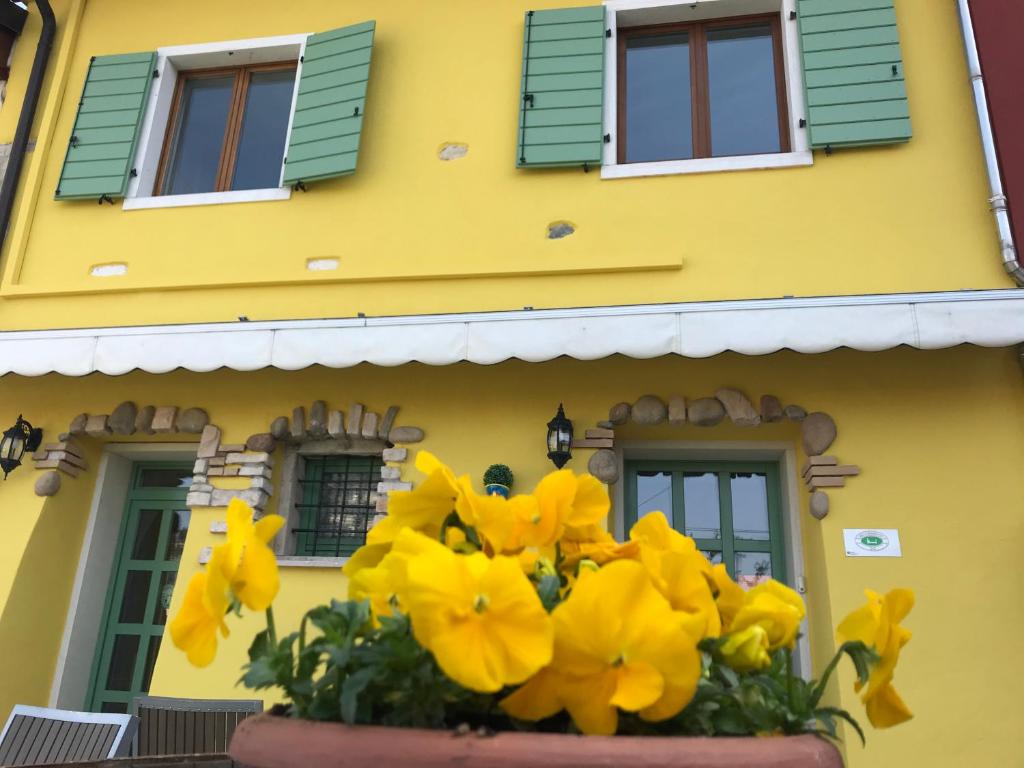 カヴァイオーン・ヴェロネーゼにあるBorgo Piccoloの花鉢を前に置いた黄色い家