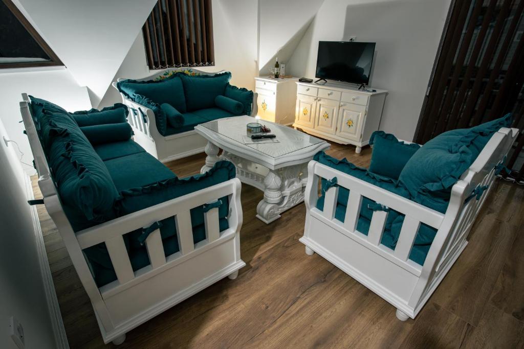 a living room with two couches and a tv at Vila ZLATARSKA PAHULJA --- apartman " BELE NOĆI " in Nova Varoš