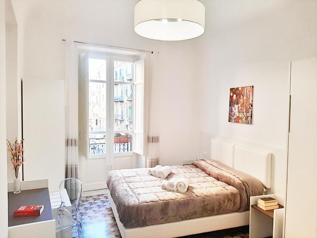- une chambre blanche avec un lit et une fenêtre dans l'établissement Ai Quartieri, à Palerme