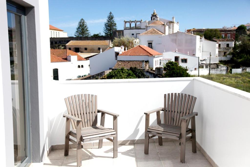 
a white chair sitting in front of a white patio at Casa a Sul - Lagos Guesthouses in Lagos
