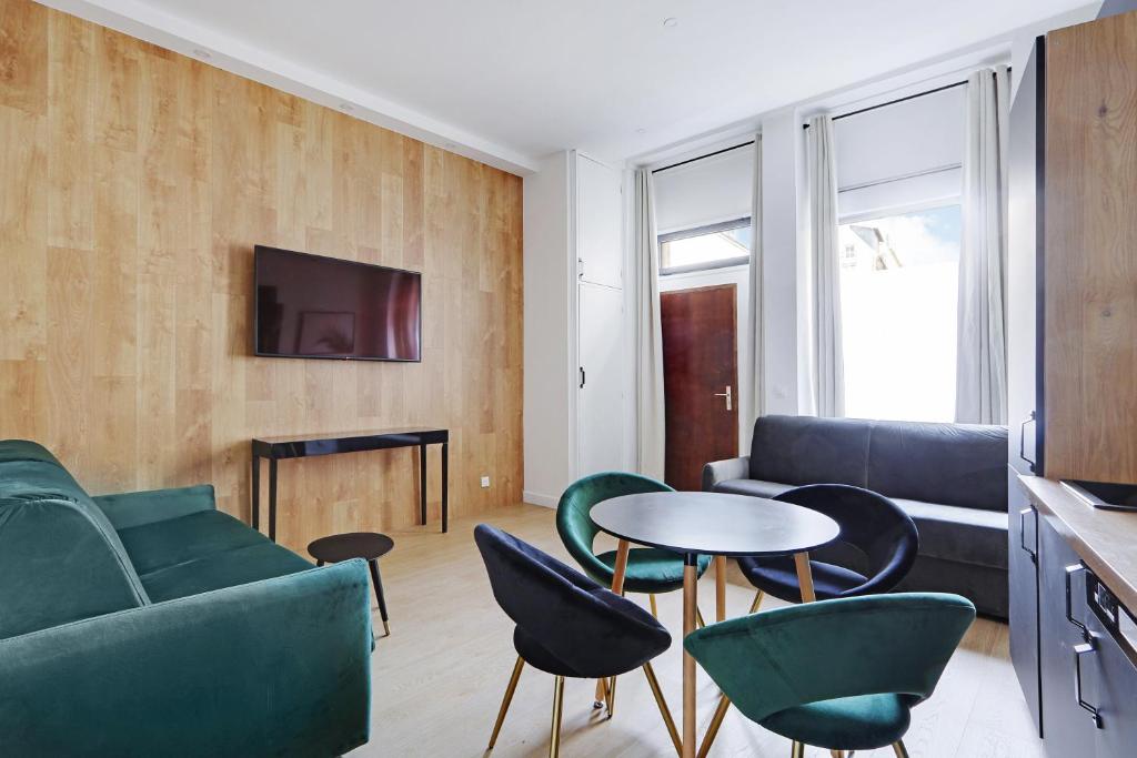 a living room with a couch and a table and chairs at Majesti apartment in Marais - Rue du Petit Musc in Paris