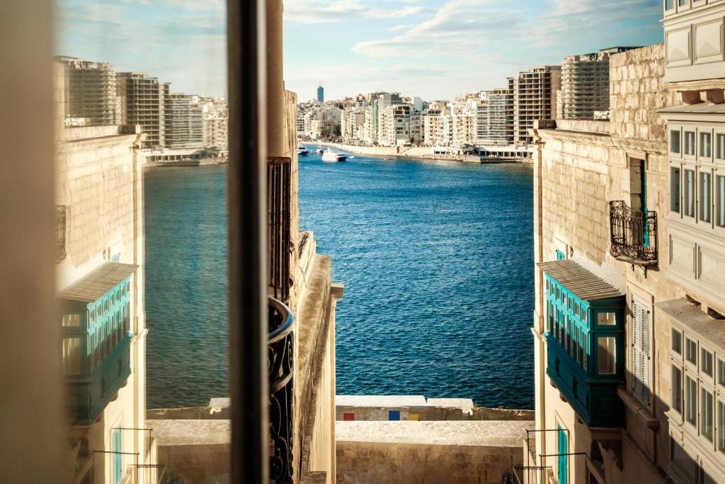 a view of the water from a window at 19 ROOMS in Valletta