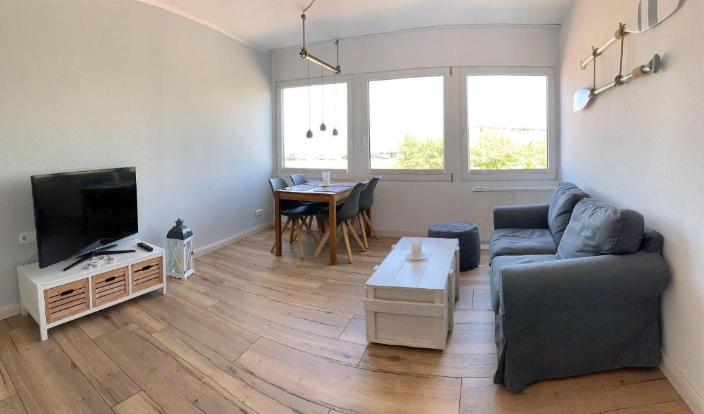 a living room with a couch and a tv and a table at derankerplatz-fehmarn in Burgtiefe auf Fehmarn 