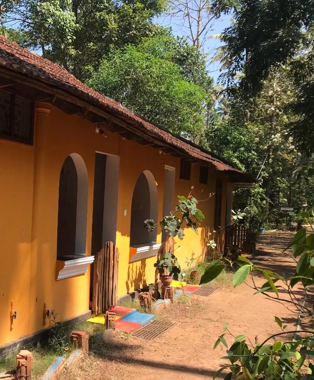 a yellow building with arches on the side of it at Jickys Nest in Varkala