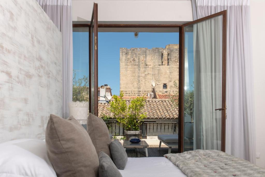 um quarto com uma cama e vista para um castelo em Maison De Mon Père em Aigues-Mortes