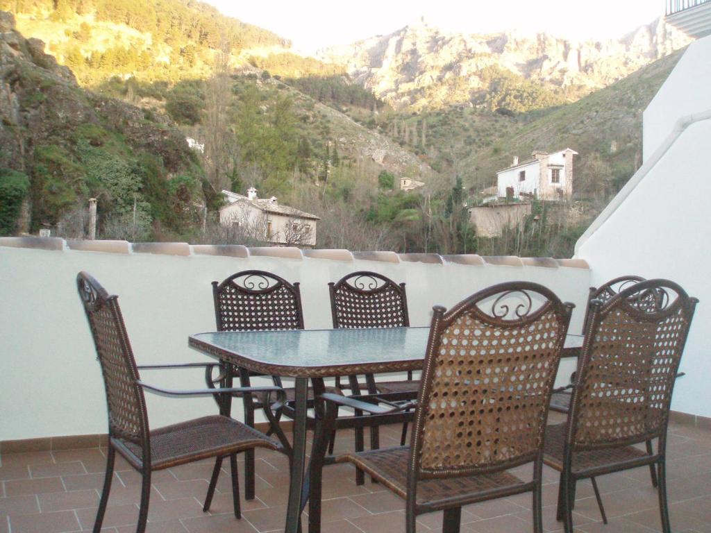 una mesa y sillas en un balcón con vistas en VFT Castillo de la Yedra, en Cazorla