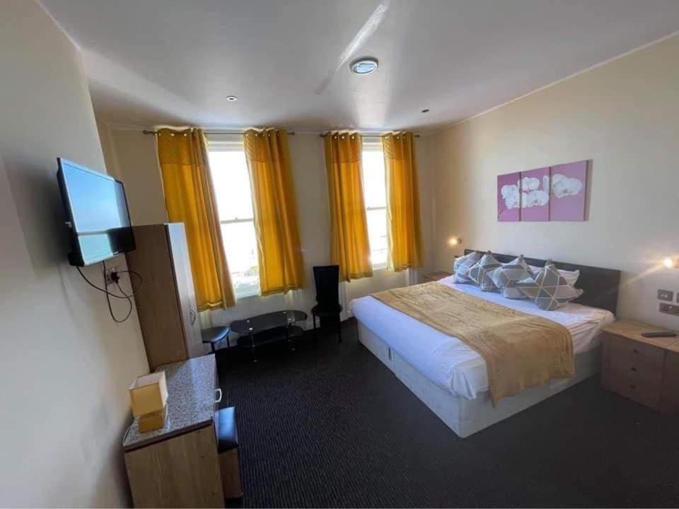
a hotel room with two beds and a television at Elsinore Hotel Llandudno in Llandudno
