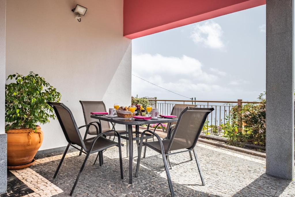 eine Terrasse mit einem Tisch und Stühlen auf dem Balkon in der Unterkunft Vivenda da Natureza in Santa Cruz