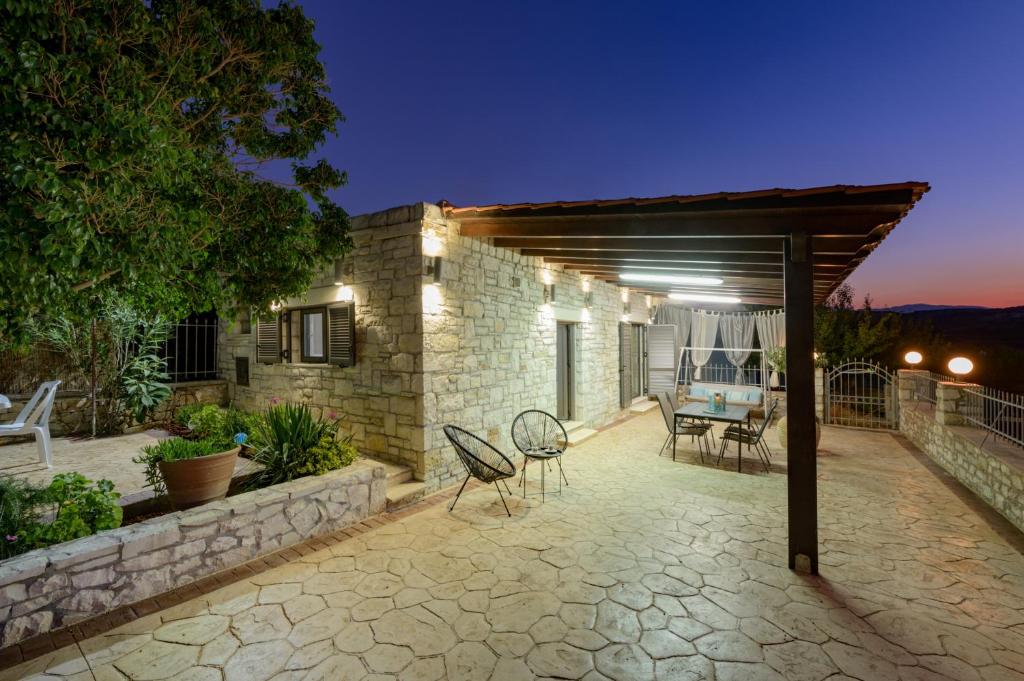 a patio with chairs and a table on a building at Arolithos Home in Almirida