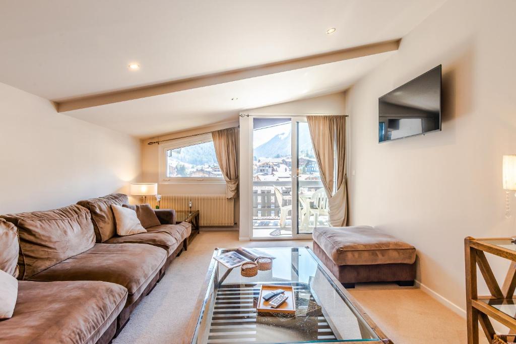 a living room with a couch and a glass table at SCHUSS D4 in Morzine