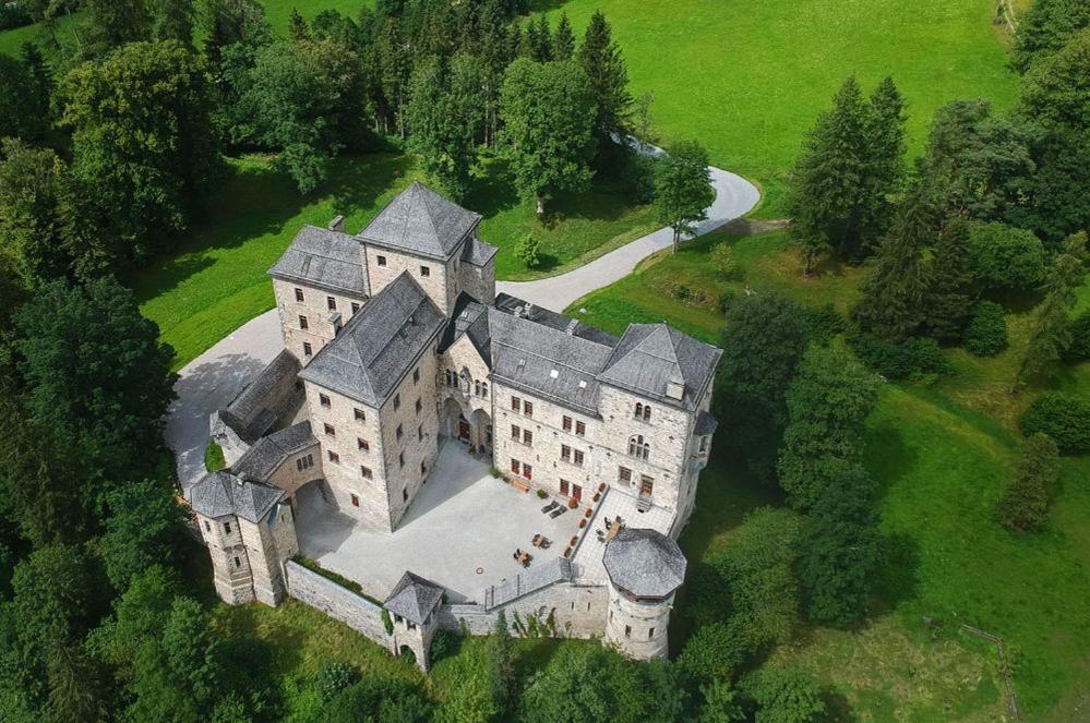 um velho castelo no meio de um campo em Schloss Fischhorn am See em Bruck an der Grossglocknerstrasse
