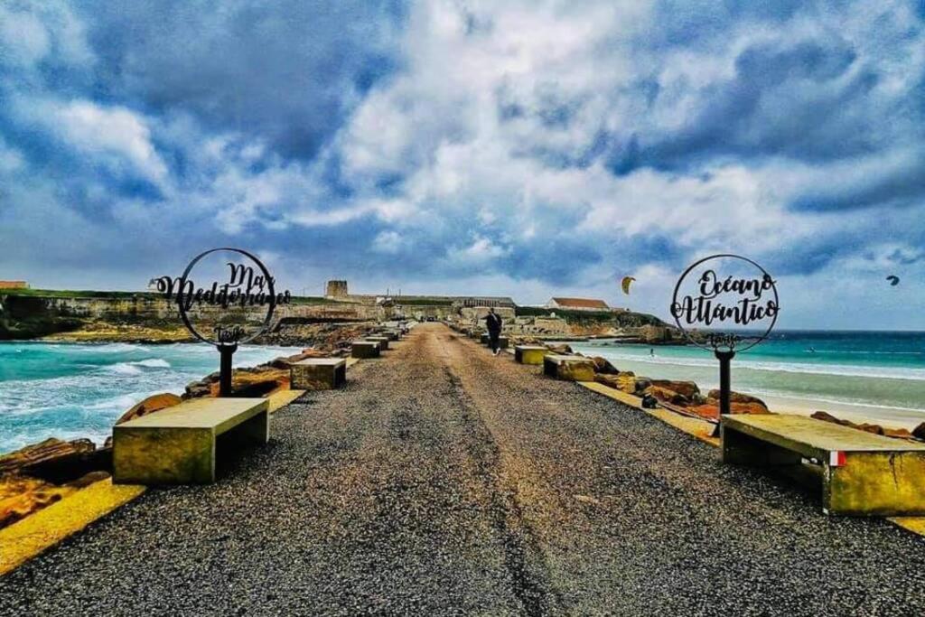 a dirt road with benches on the beach at Apartamento Lances playa tarifa in Tarifa