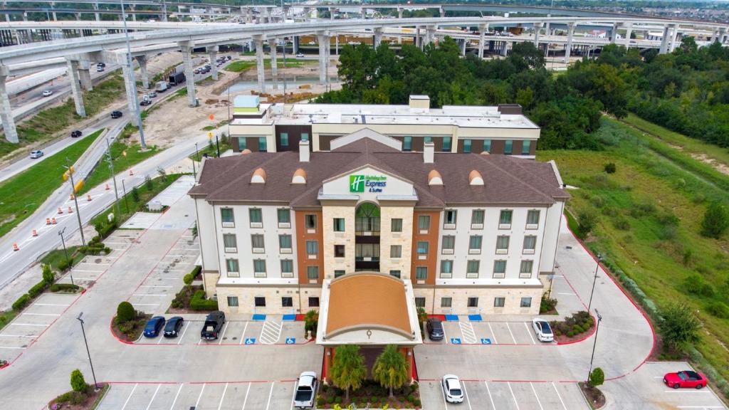 a large white building with a brown roof at Holiday Inn Express & Suites Houston South - Near Pearland by IHG in Houston