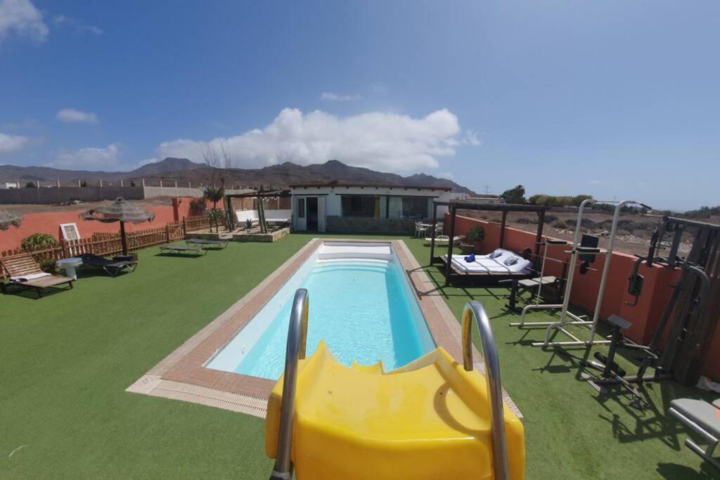 een zwembad met een glijbaan in een tuin bij Sueño Playitas in Las Playitas