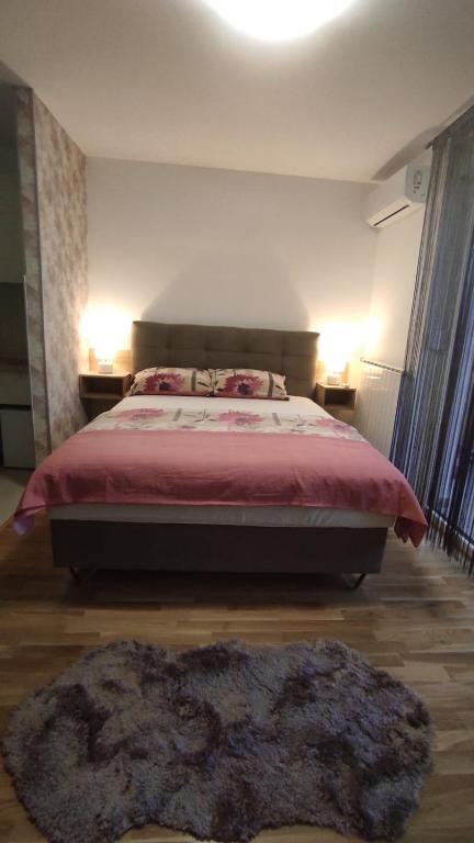 a bedroom with a large bed and a large rug at M&I Apartment in Doboj
