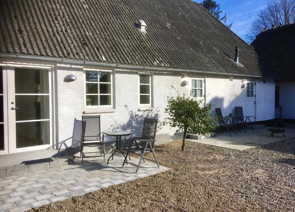 a white house with chairs and a table in front of it at Kroghøjgård in Middelfart